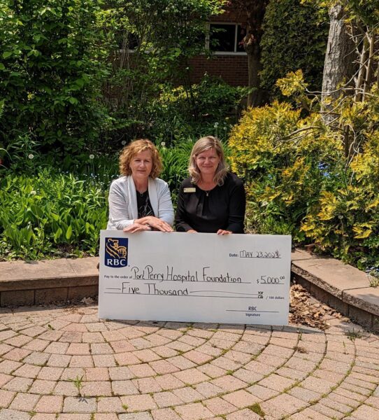 Rachel Agnoluzzi sitting with Lisa Kelly in the garden for cheque presentation in the amount of $5000